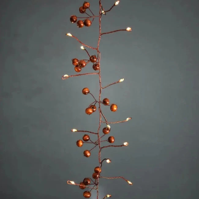 Copper wire string lights with small, brown berry accents.