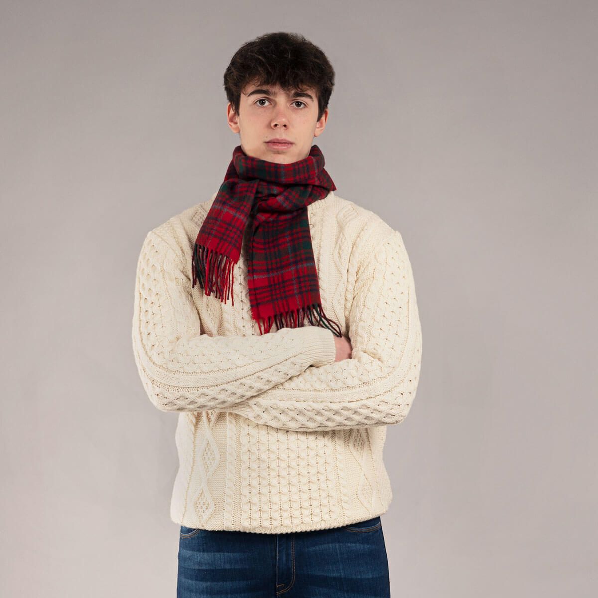 Cream cable knit sweater with a red and green plaid scarf.