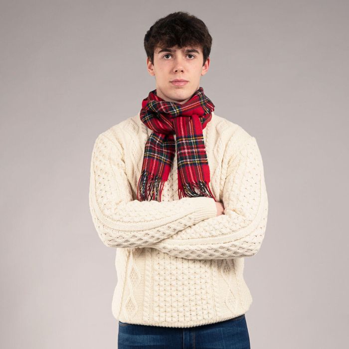 Cream cable knit sweater with a red and green plaid scarf.