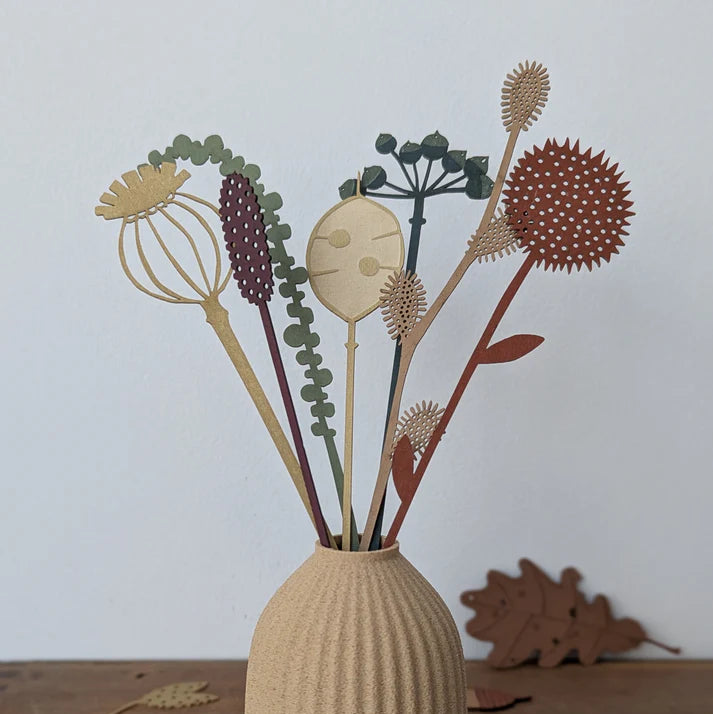 Decorative vase with dried flowers against a plain background
