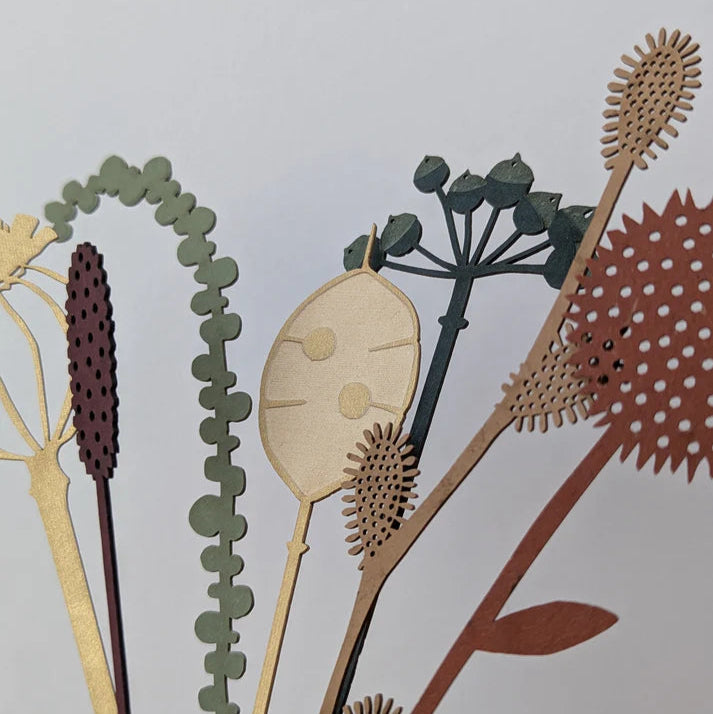 Decorative cutout of dried plants on a light gray background