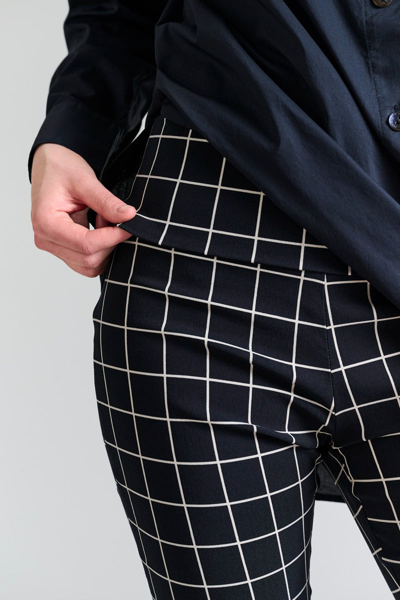 Person wearing black checkered pants with a plain background