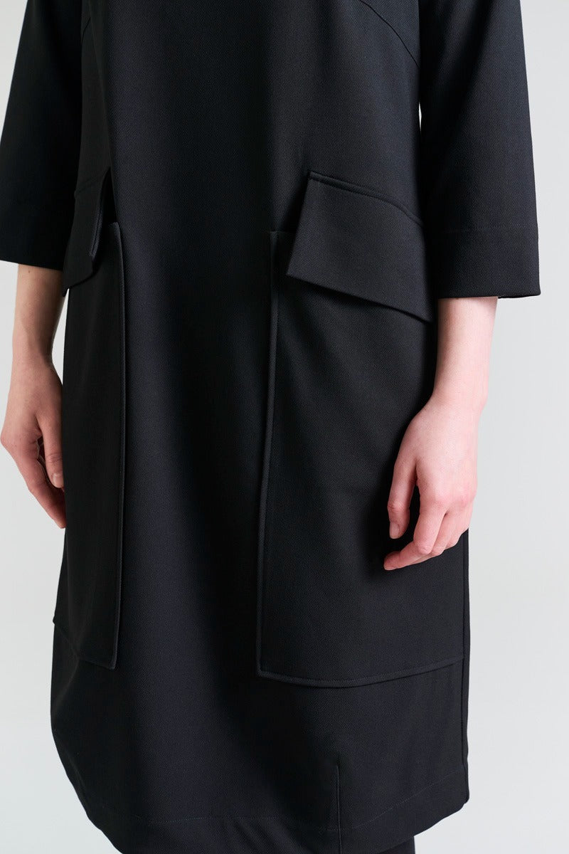 Black coat worn by a person on a light gray background