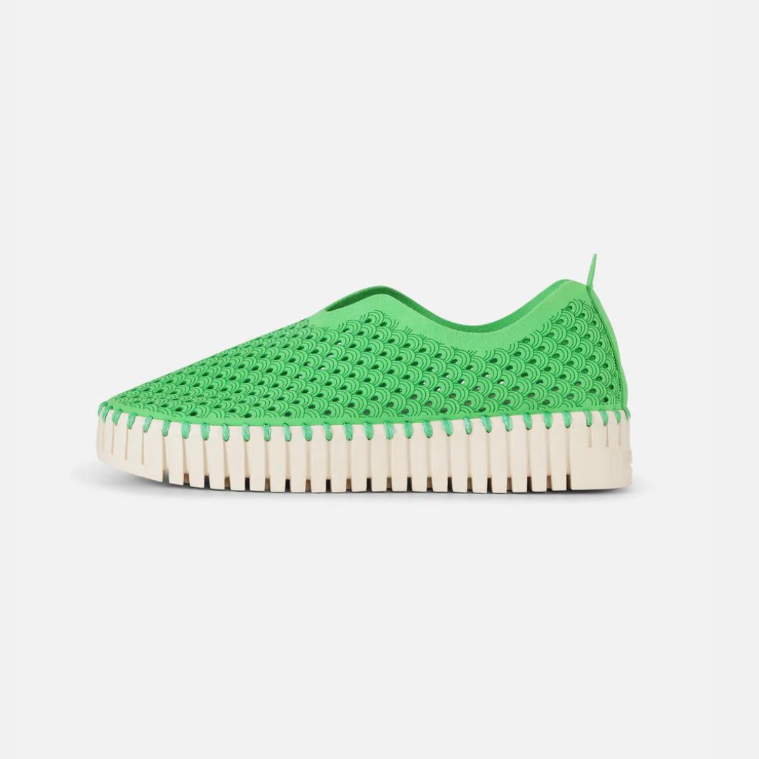 Bright green slip-on sneaker with textured, perforated upper and cream-colored, ridged sole.