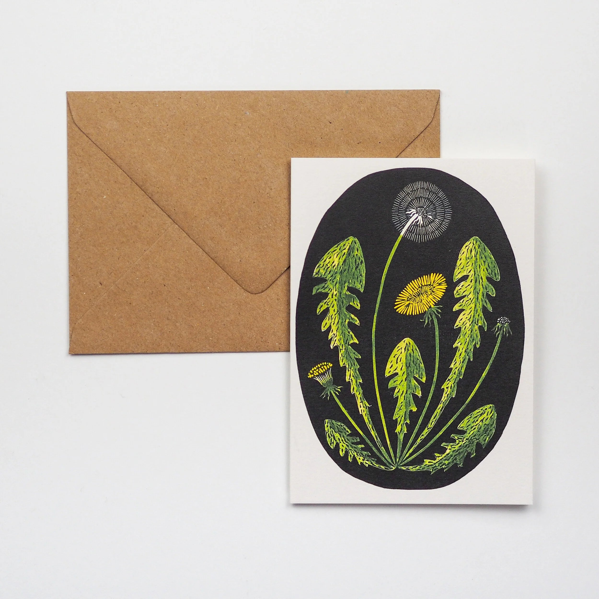 Dandelion-themed greeting card featuring stylized green leaves and yellow and white flower heads in an oval on a black