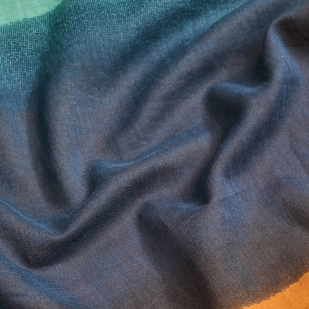 Ombre fabric in teal, blue, and orange hues, showing texture and soft draping.