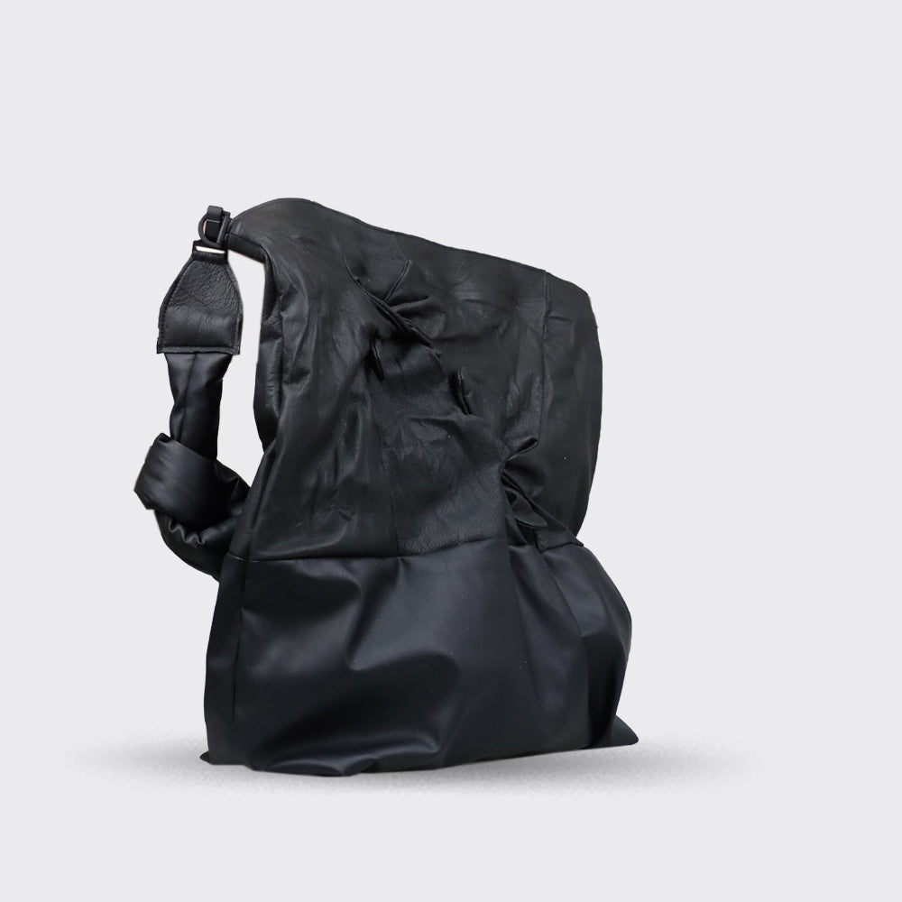 Black leather and nylon shoulder bag with a knotted detail and a structured, slightly gathered design.