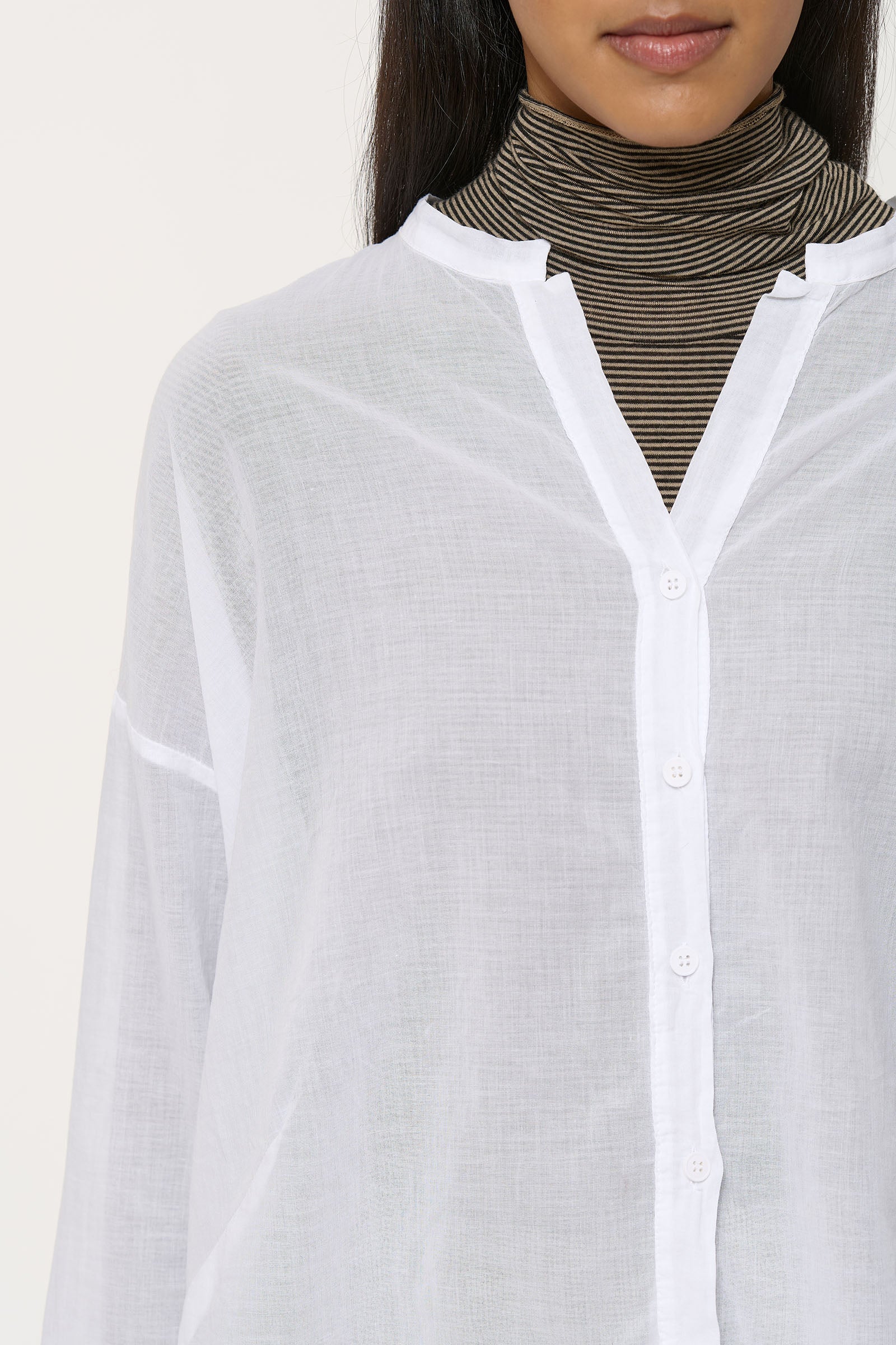 White sheer button-down shirt with a V-neck and long sleeves. The fabric has a slightly textured appearance.