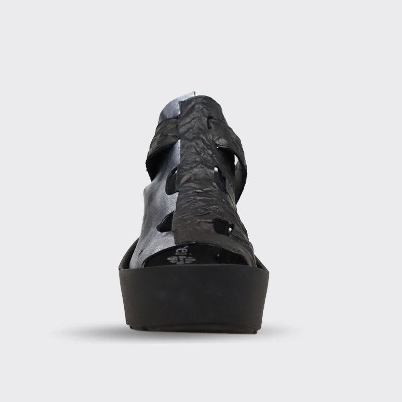 Black and silver leather wedge sandal with cut-out detailing and ankle strap.