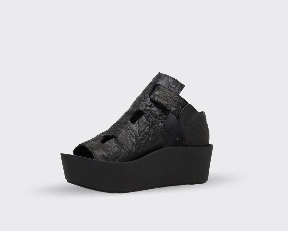 Black leather platform sandal with cut-out detailing and a textured upper.