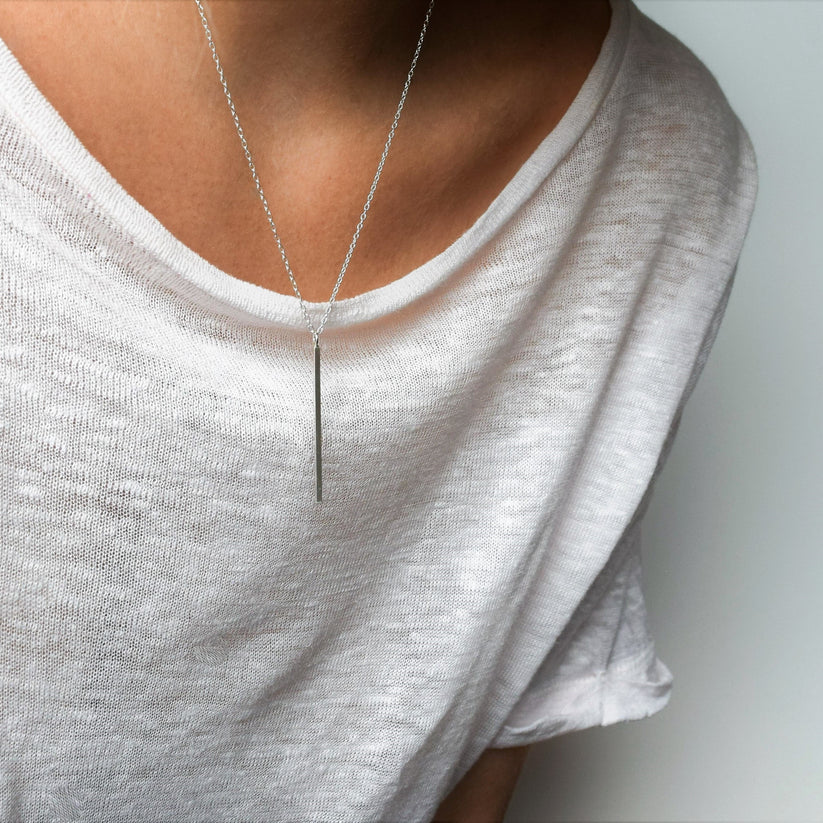 Silver bar pendant necklace on a delicate chain.