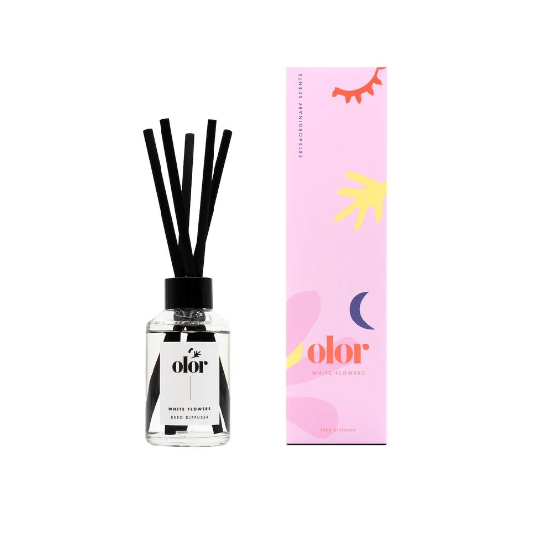 Olor White Flowers reed diffuser in clear glass bottle with black reeds and matching pink and white box.