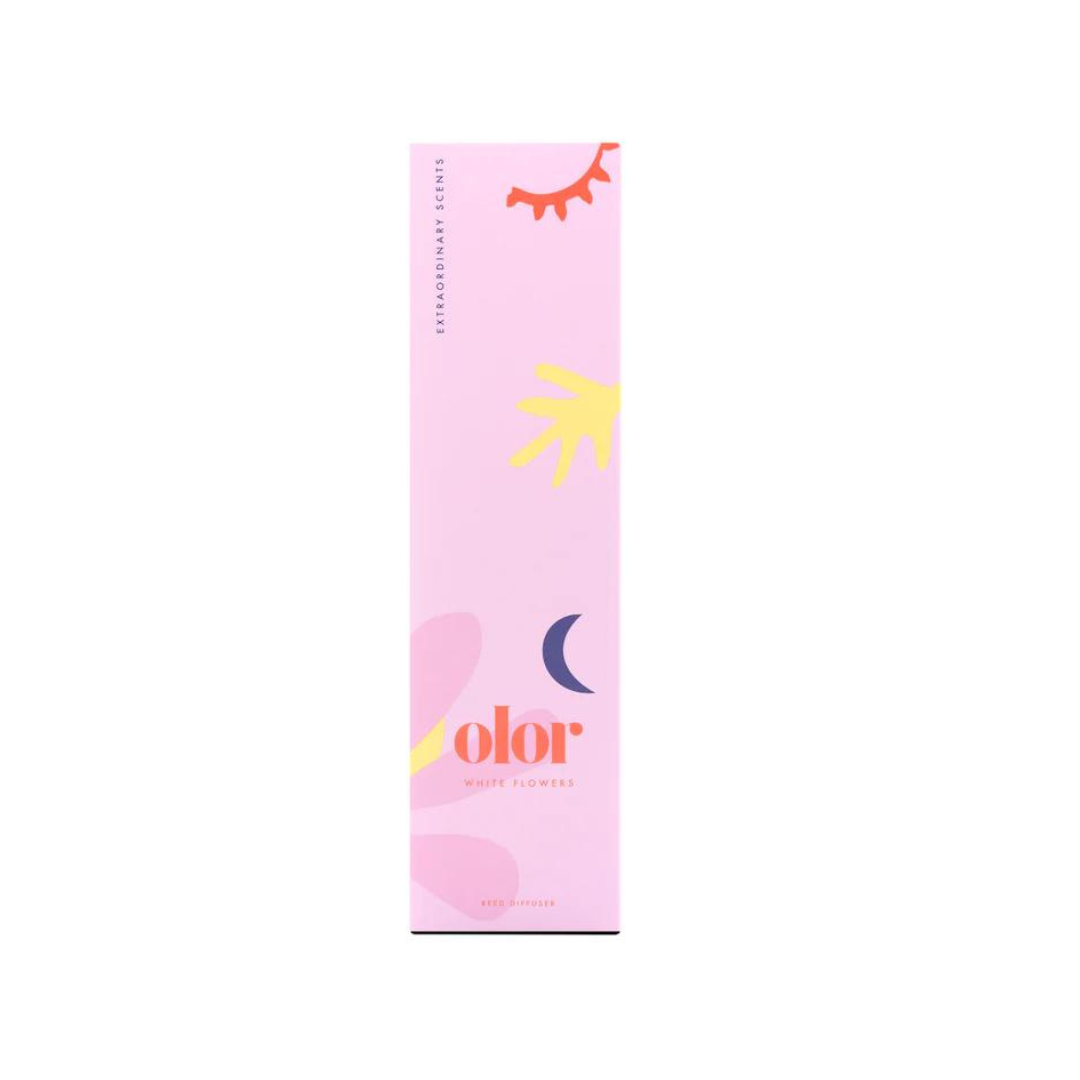 Reed diffuser box; pink background with stylized floral and celestial designs; "olor White Flowers" text.