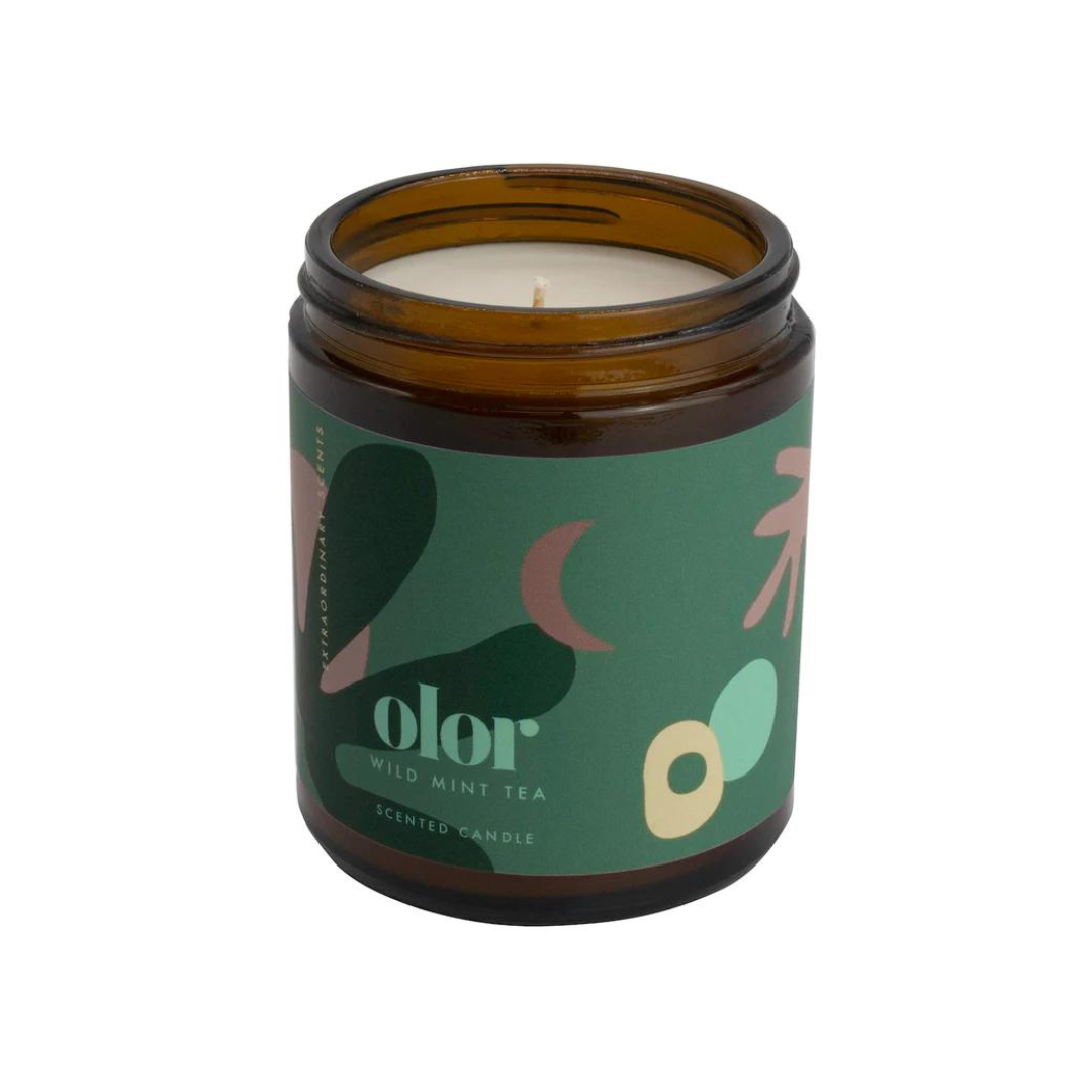 Amber jar candle with a green label;  "olor Wild Mint Tea Scented Candle" is printed on the label.