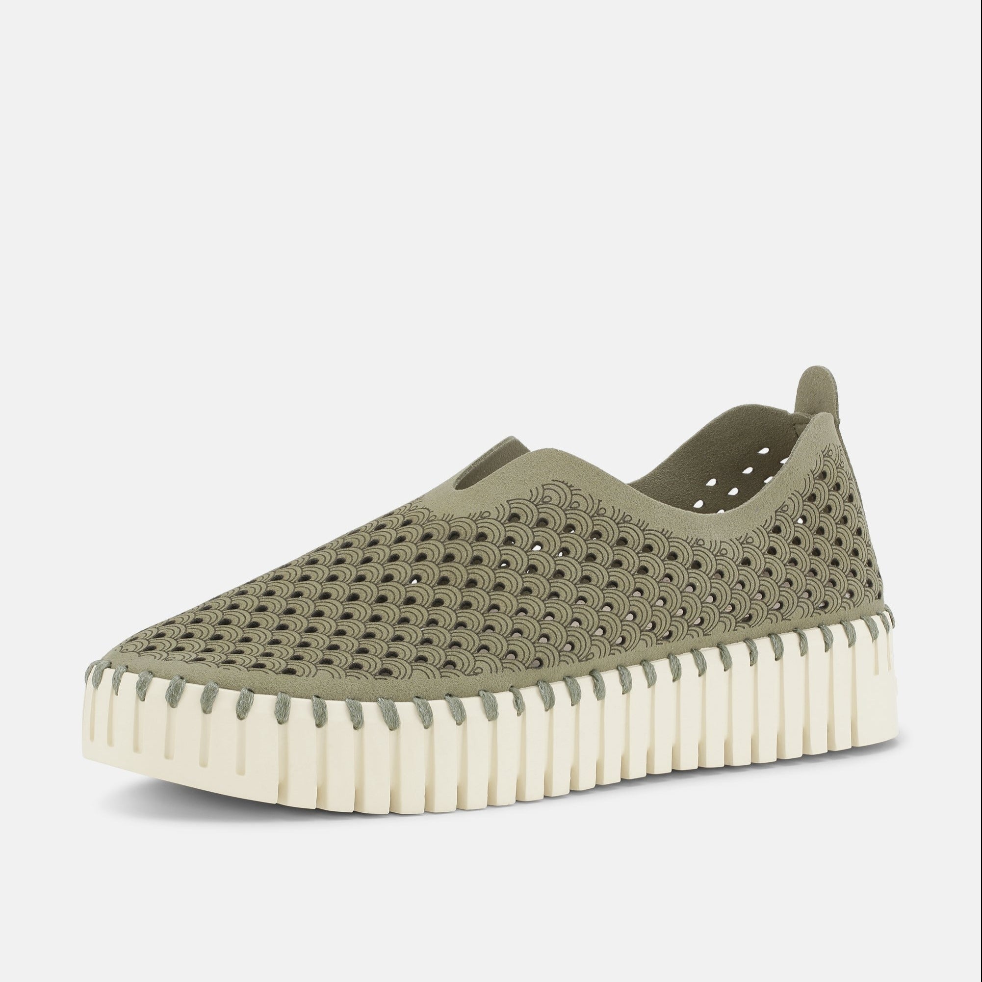 Sage green slip-on shoe with a wave pattern and off-white, ridged sole. The upper is perforated with a dark gray wave design.