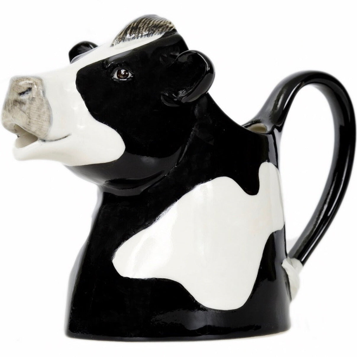 Black and white ceramic cow creamer. The creamer is shaped like a cow's head and has a handle.