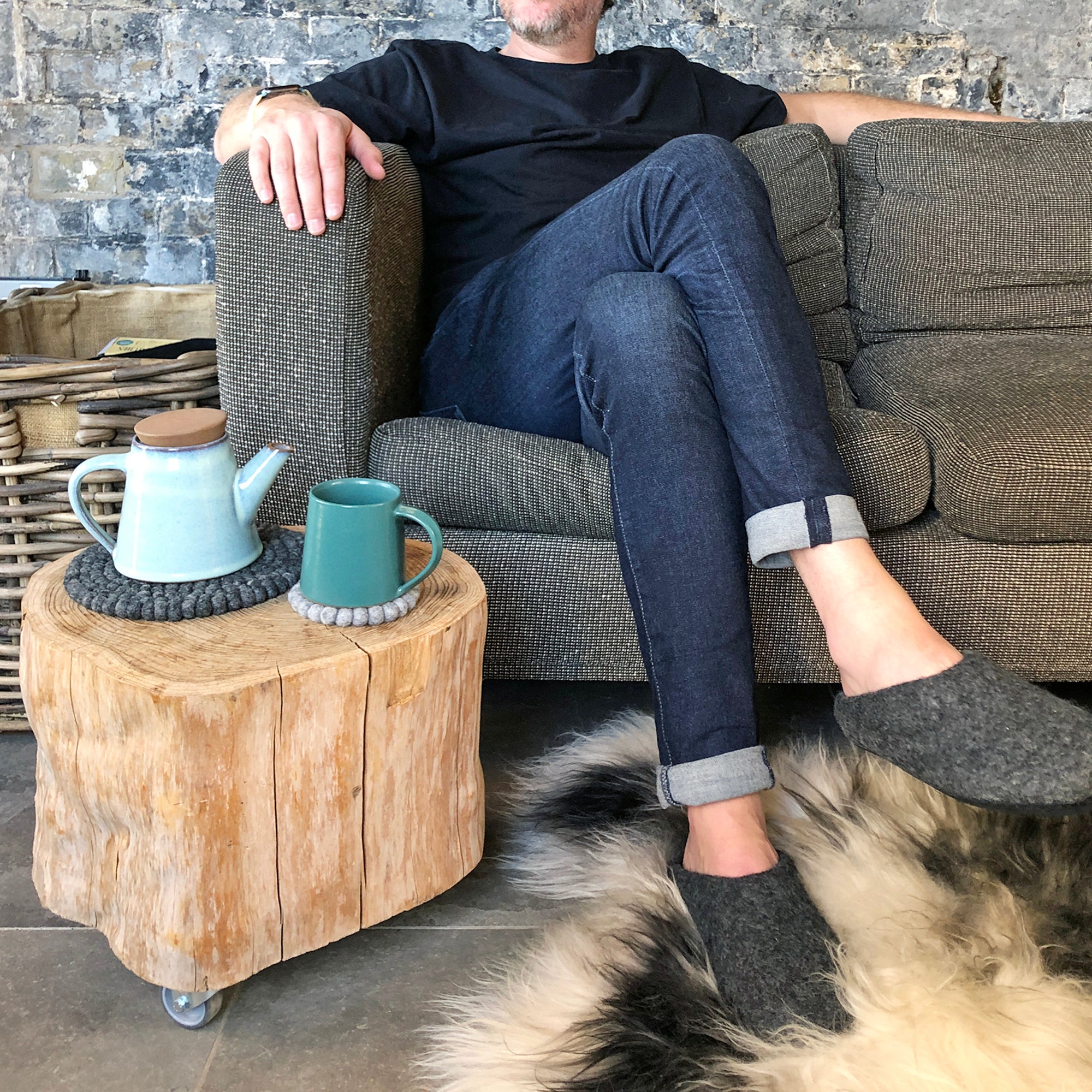 A light blue teapot and teal mug rest on a tree trunk side table.