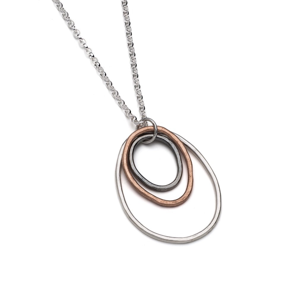 Silver chain necklace with a pendant featuring three overlapping oval shapes in silver, copper, and dark gray.
