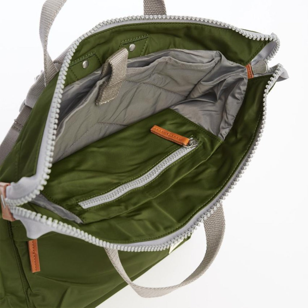 Olive green tote bag with light grey zipper accents and interior lining. Features a small zippered pocket inside.