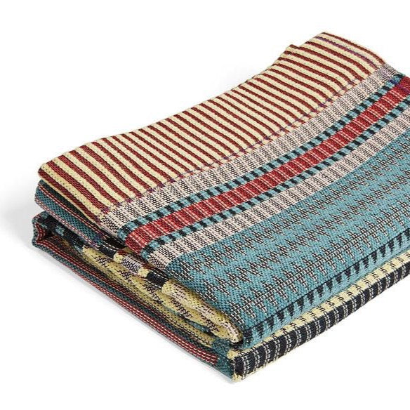 Multicolored woven throw blanket with teal, red, and yellow stripes and patterns.
