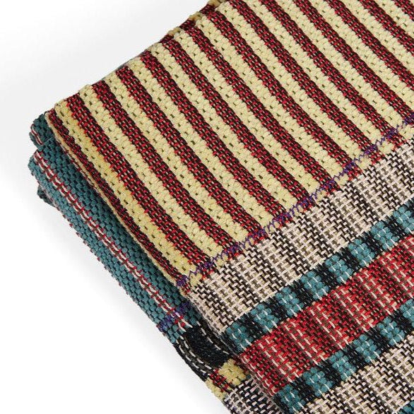 Multicolored woven throw blanket with red, beige, teal, and gray stripes and textured patterns.