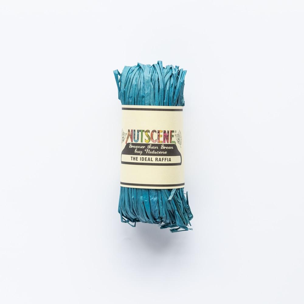 Teal raffia roll with "Nutscene" label; "Greener than Green buy Nutscene" and "The Ideal Raffia" are printed on the label.