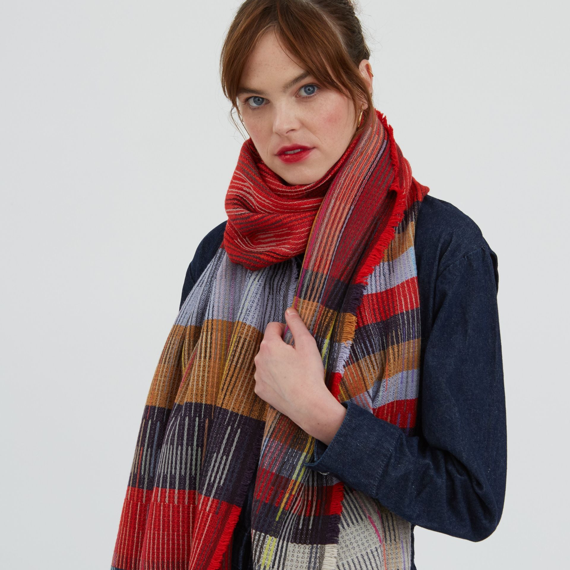 Red, tan, and gray plaid woven scarf with frayed edges.