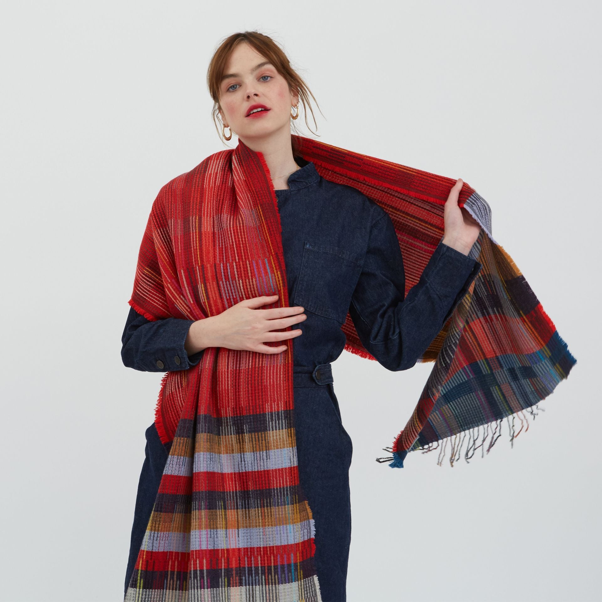 Red, multicolored striped wool scarf with fringed edges.