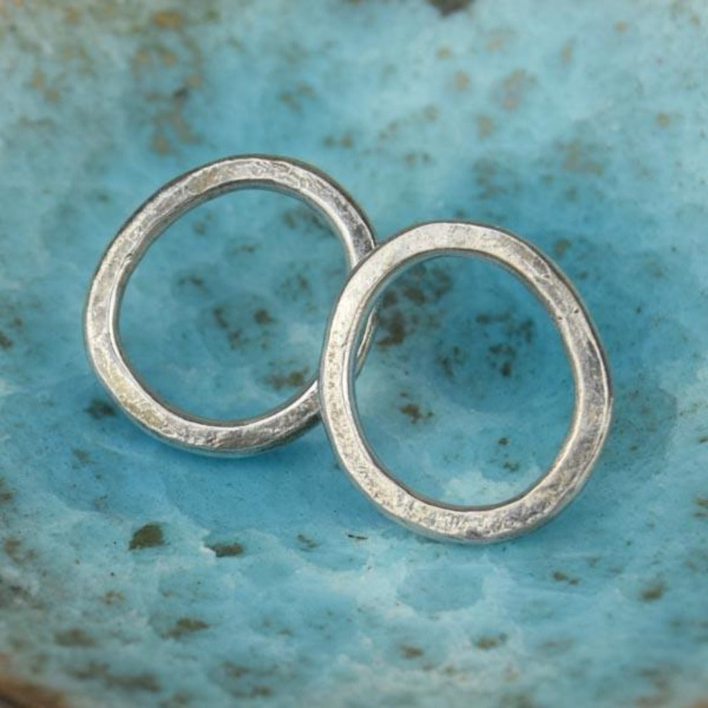 Pair of silver circle stud earrings with a hammered texture.