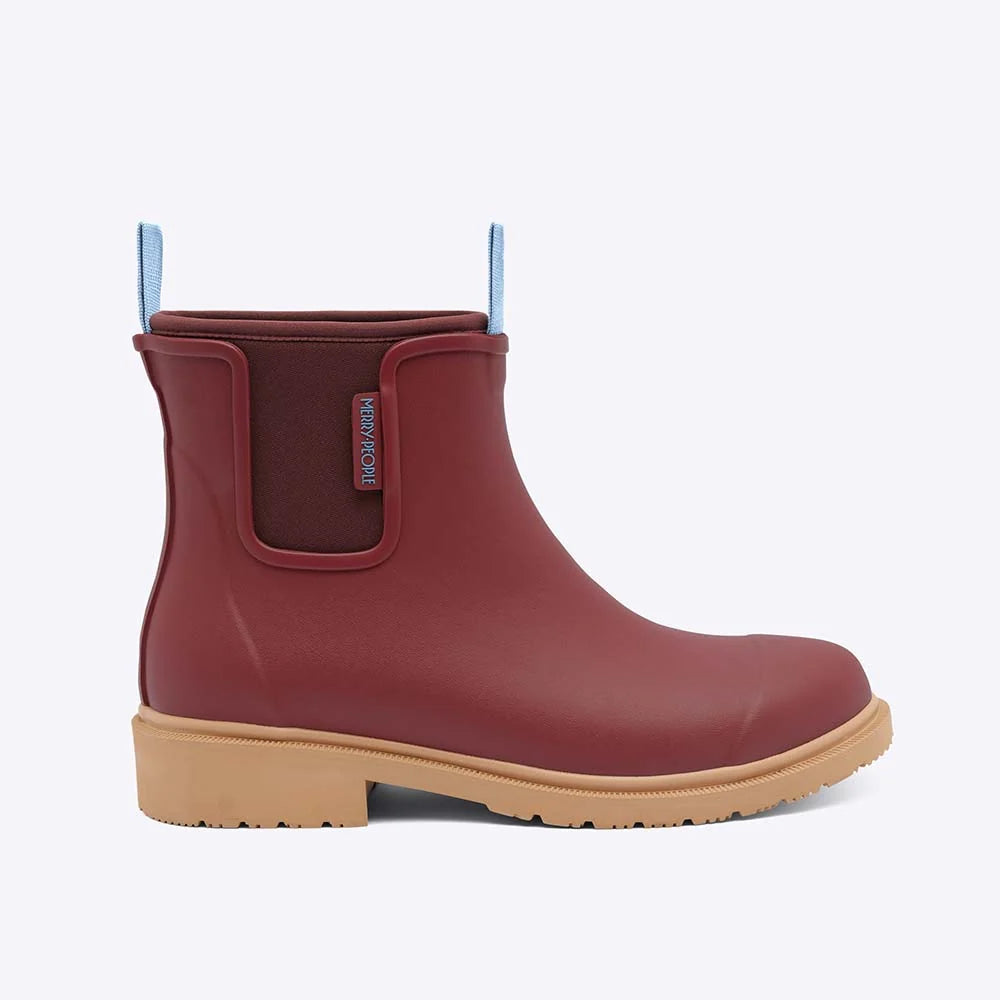 Red rubber boot with a beige sole on a white background