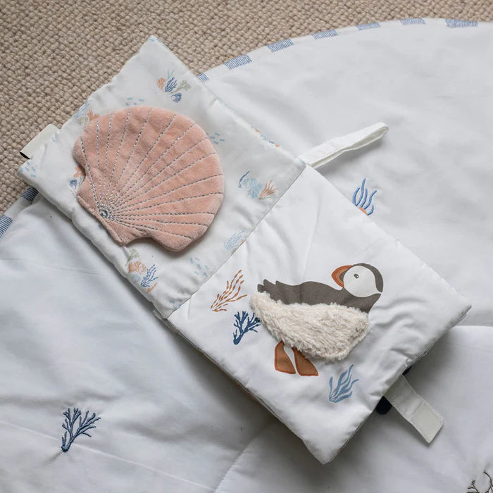 Baby comfort blanket with puffin design and pink shell on a textured surface