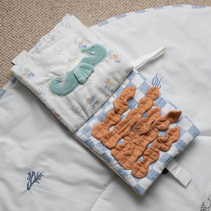Baby comfort blanket with seahorse and coral design on a textured surface
