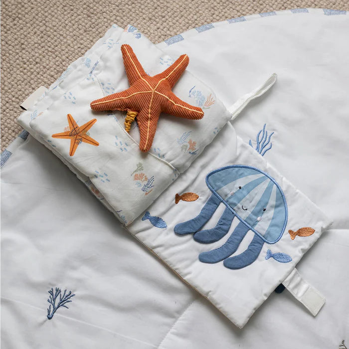 Children's blanket with starfish and jellyfish designs on a textured surface