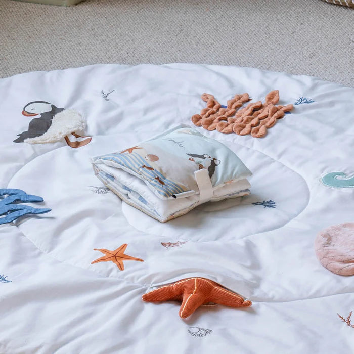 Children's book on a soft surface with sea-themed illustrations