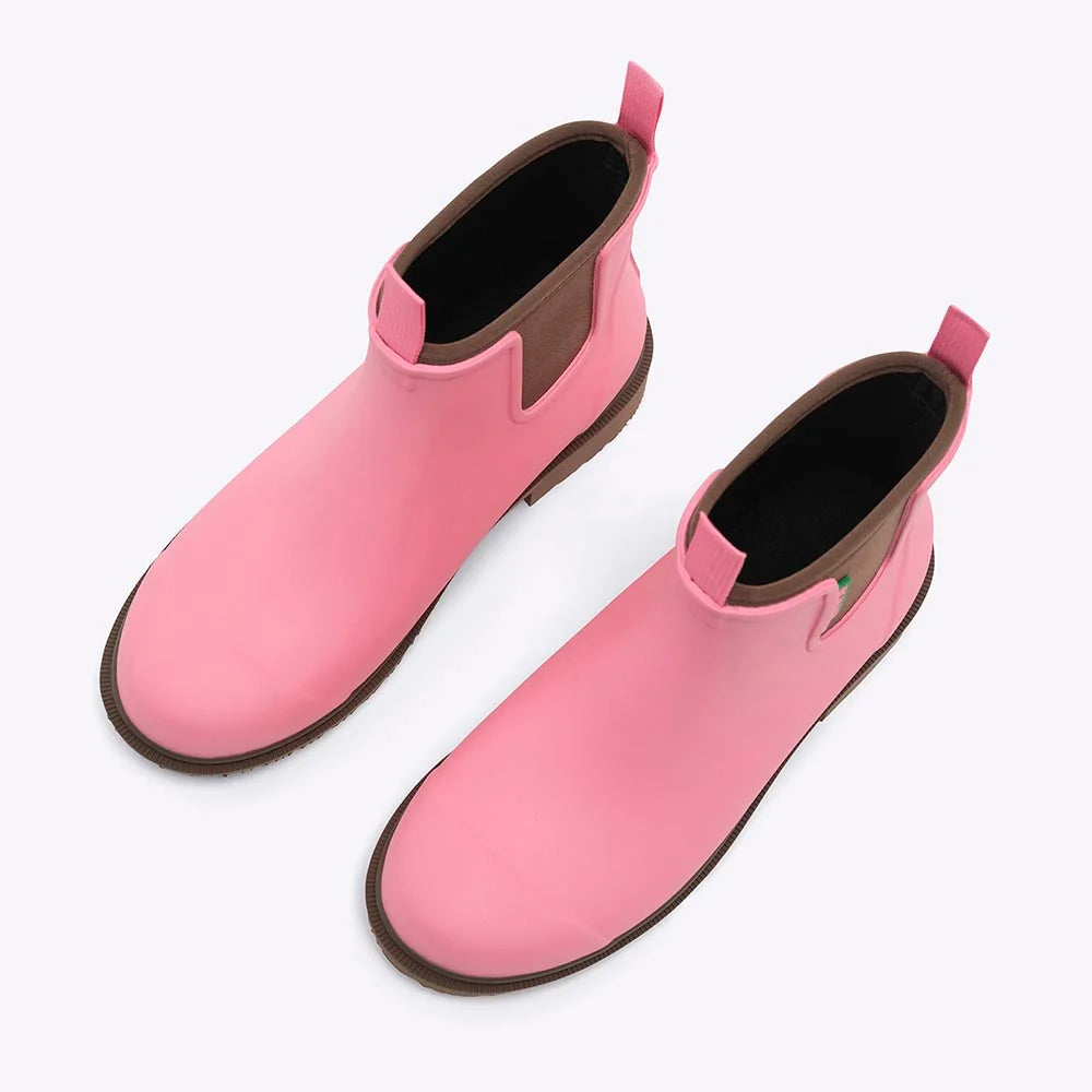 A pair of pink Chelsea-style rain boots with brown soles and dark interiors, shown on a plain white background.