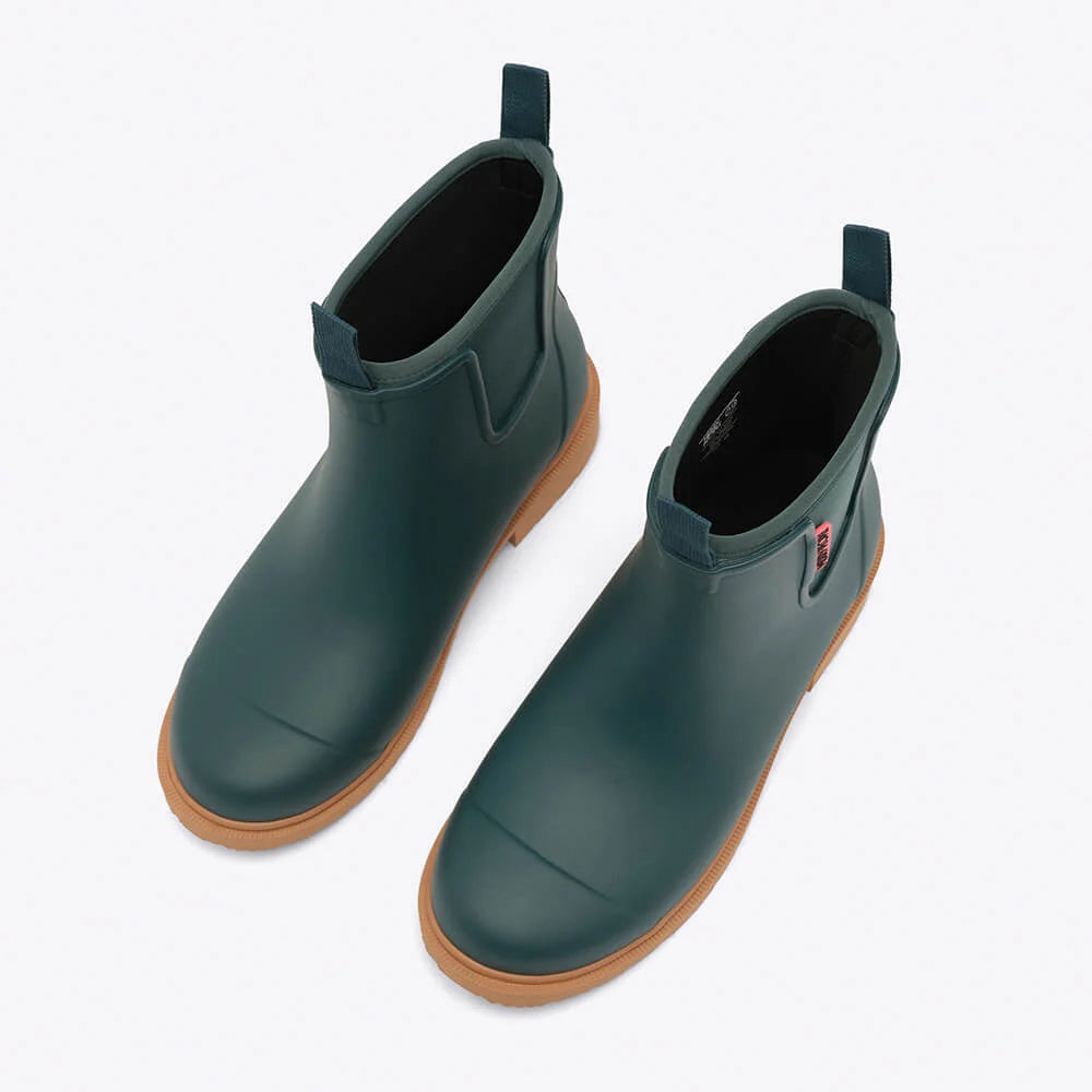 Pair of green rubber boots with brown soles on a white background