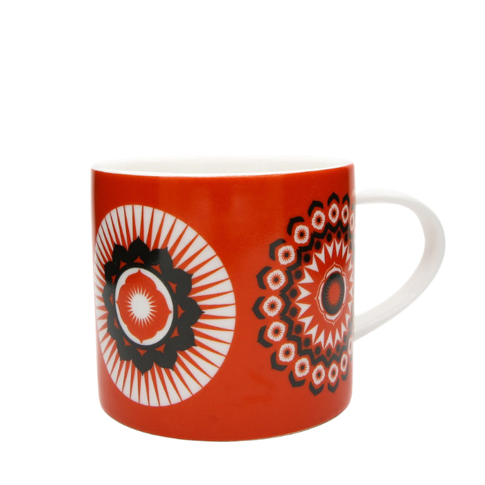 Orange mug with black and white geometric mandala designs.