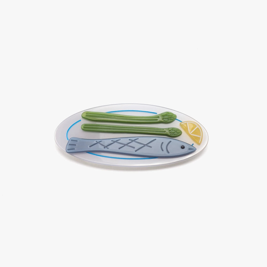 Decorative hair clips featured a fish and vegetable design sits on a white background