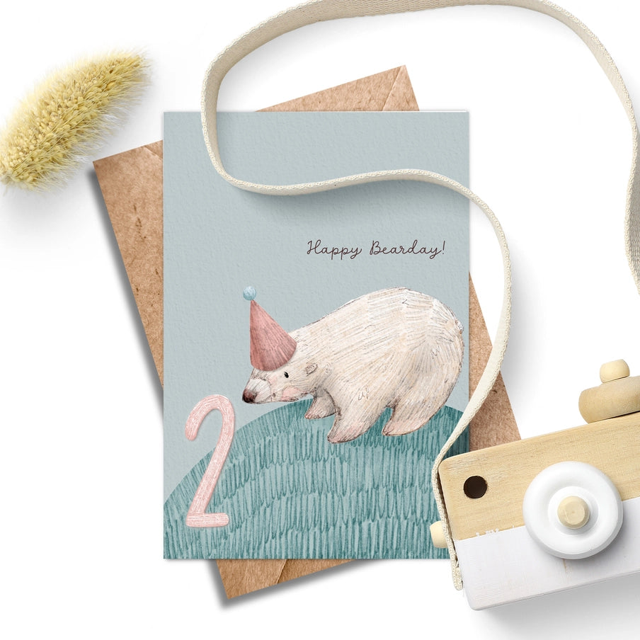 Second birthday card featuring a polar bear wearing a party hat, next to the number two.