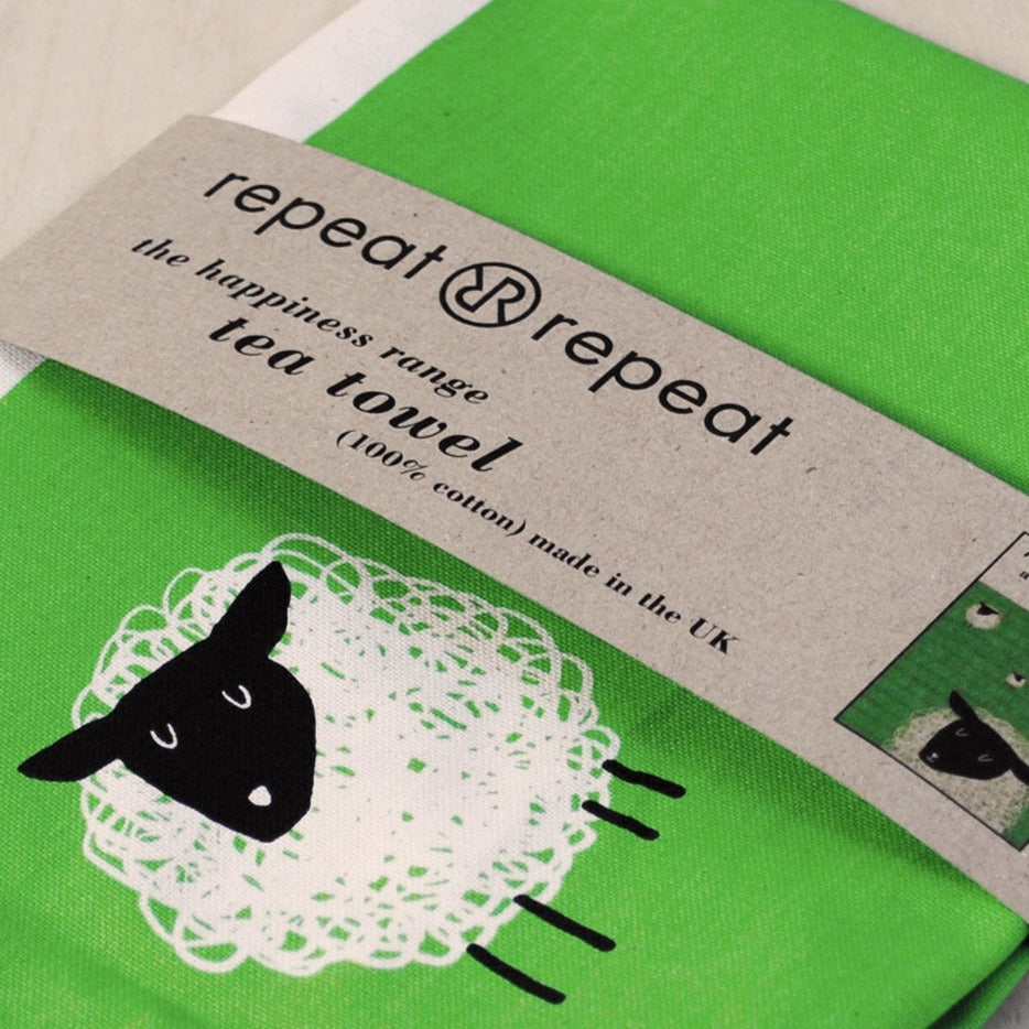 Bright green tea towel with a black and white sheep design.  100% cotton, made in the UK.