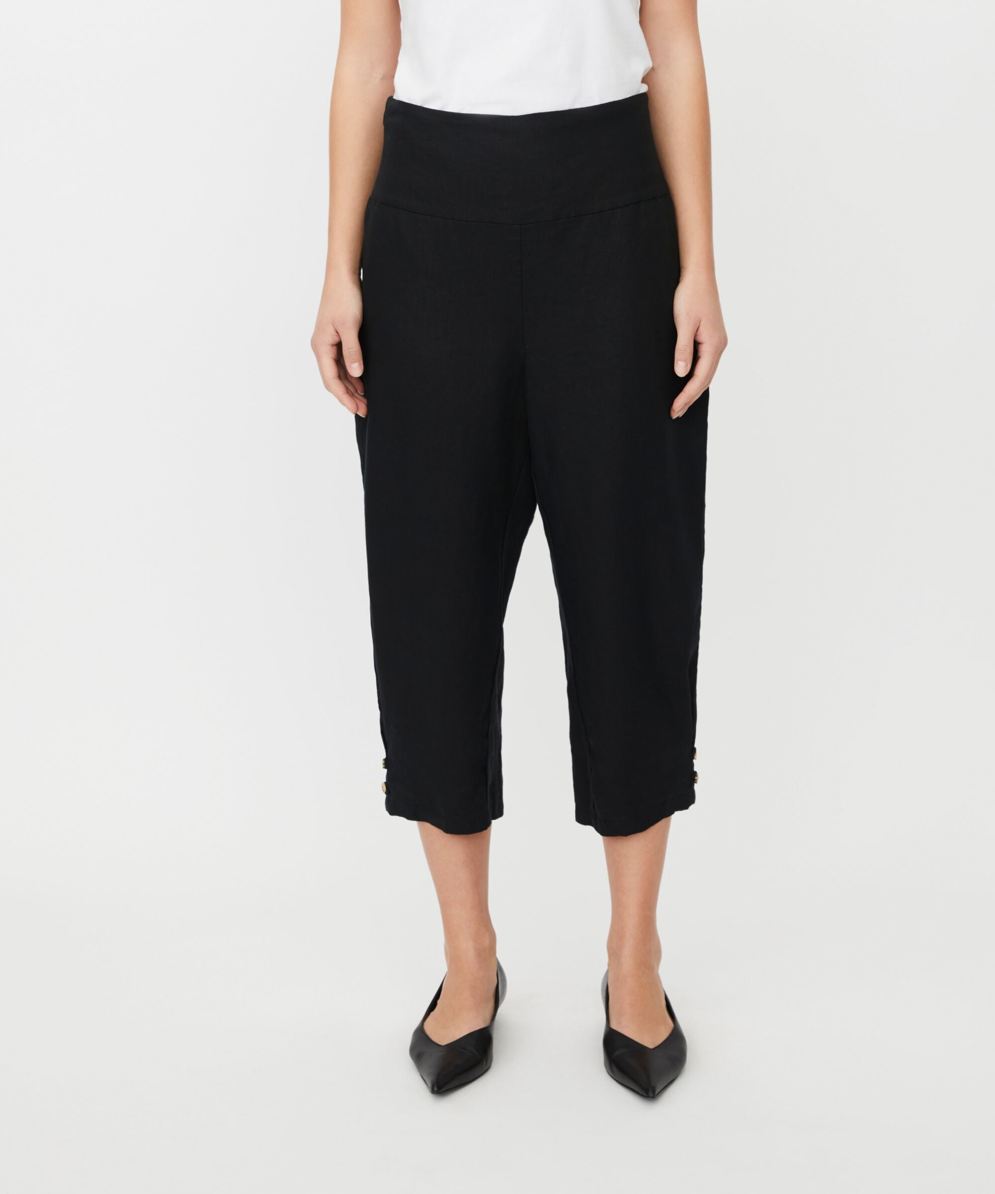 Person wearing black capri pants on a white background