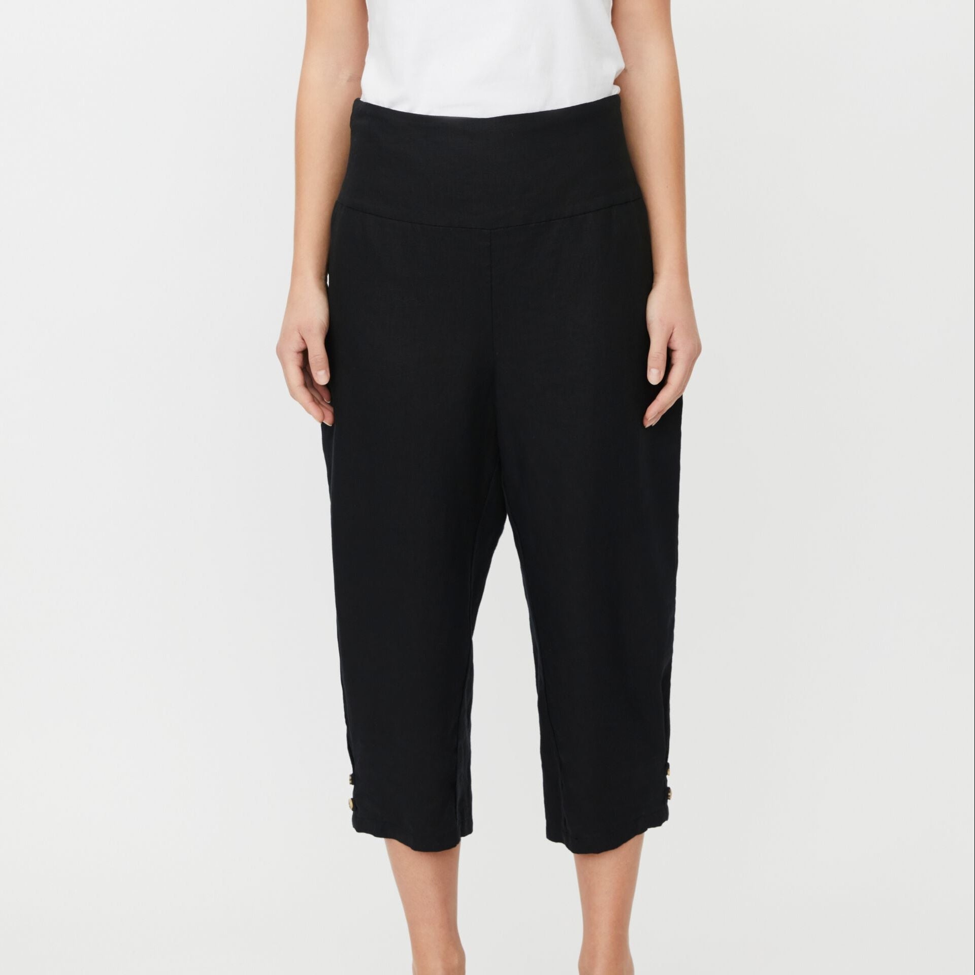 Black capri pants worn by a person on a white background