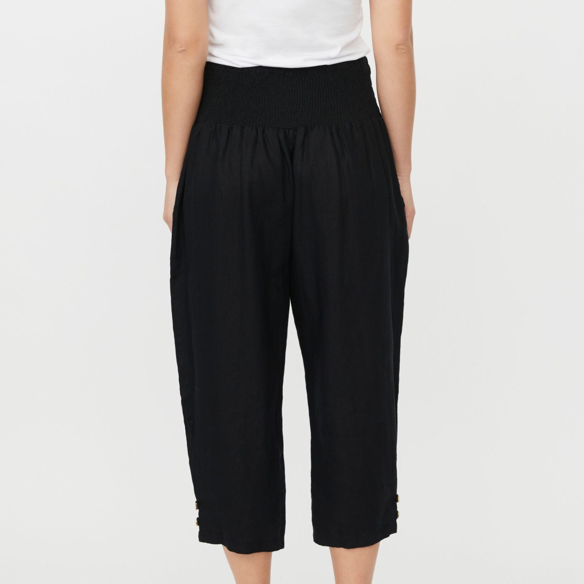 Person wearing black capri pants on a light gray background