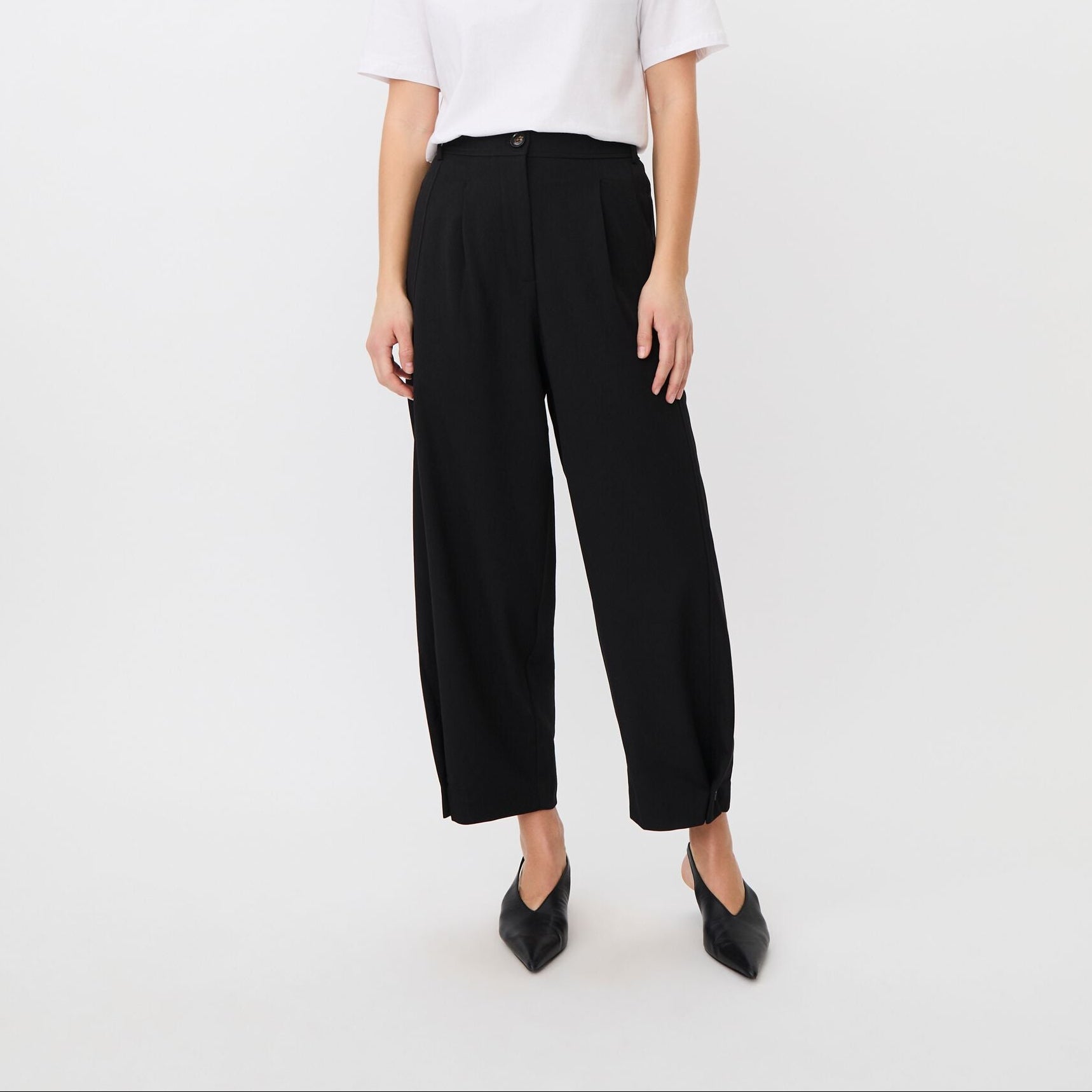 Person wearing black pants on a white background