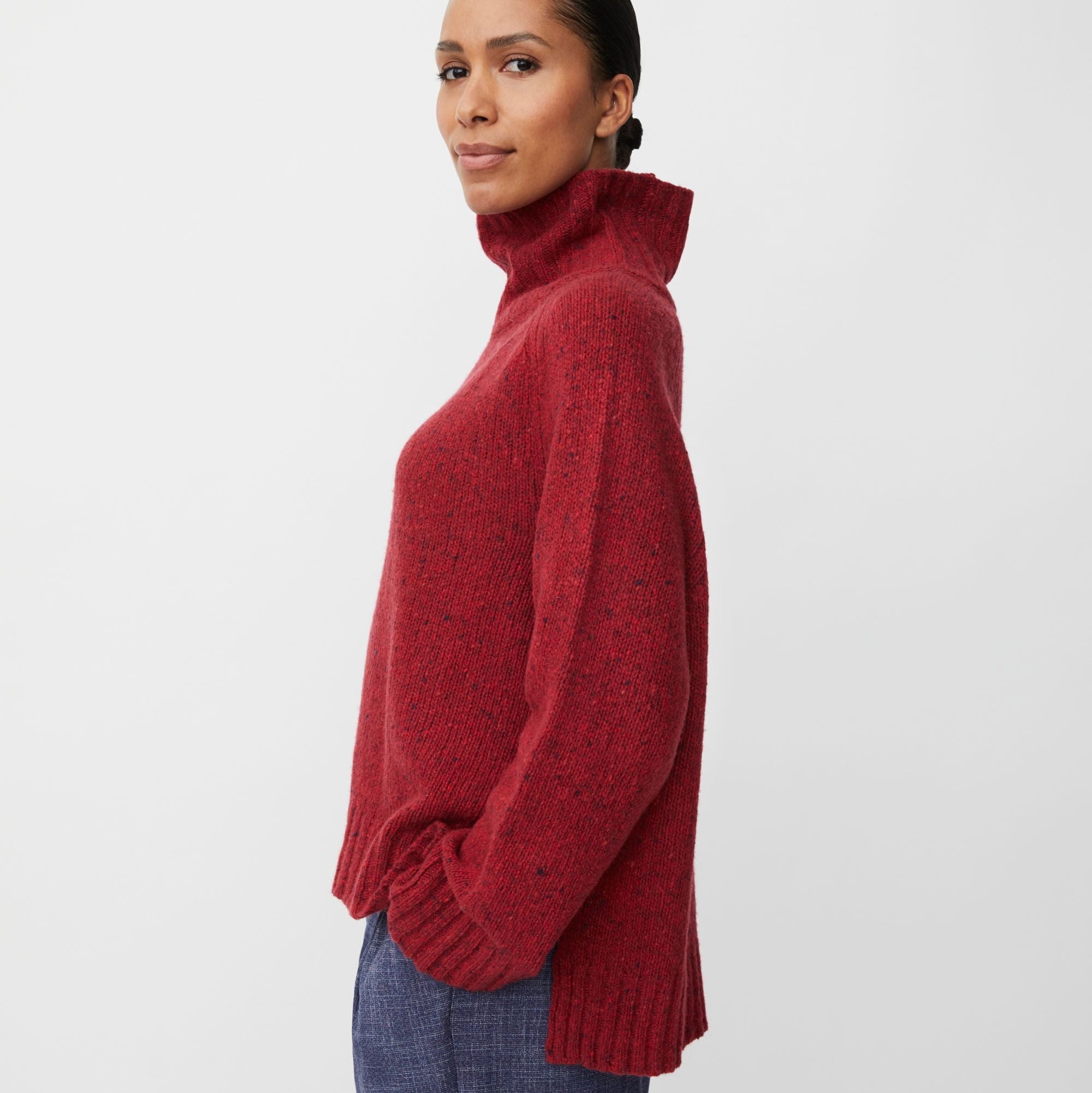 Woman wearing a red sweater against a white background