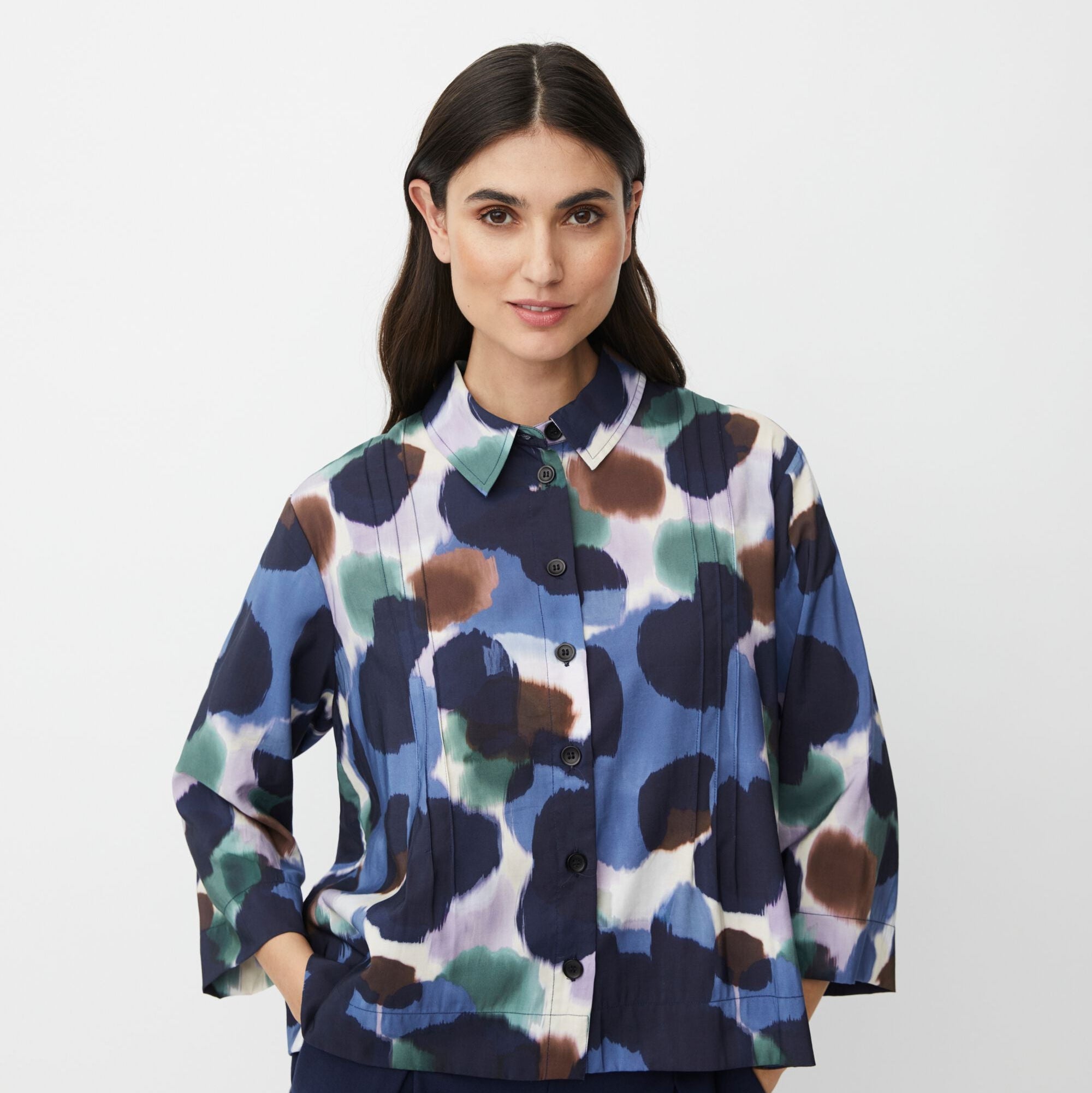 Abstract print button-down shirt with three-quarter sleeves.  Blues, greens, browns, and purples dominate the design.