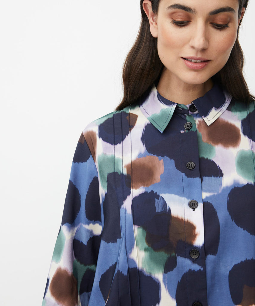 Abstract print button-down shirt in shades of blue, brown, and green.  Long sleeves, collared neckline.