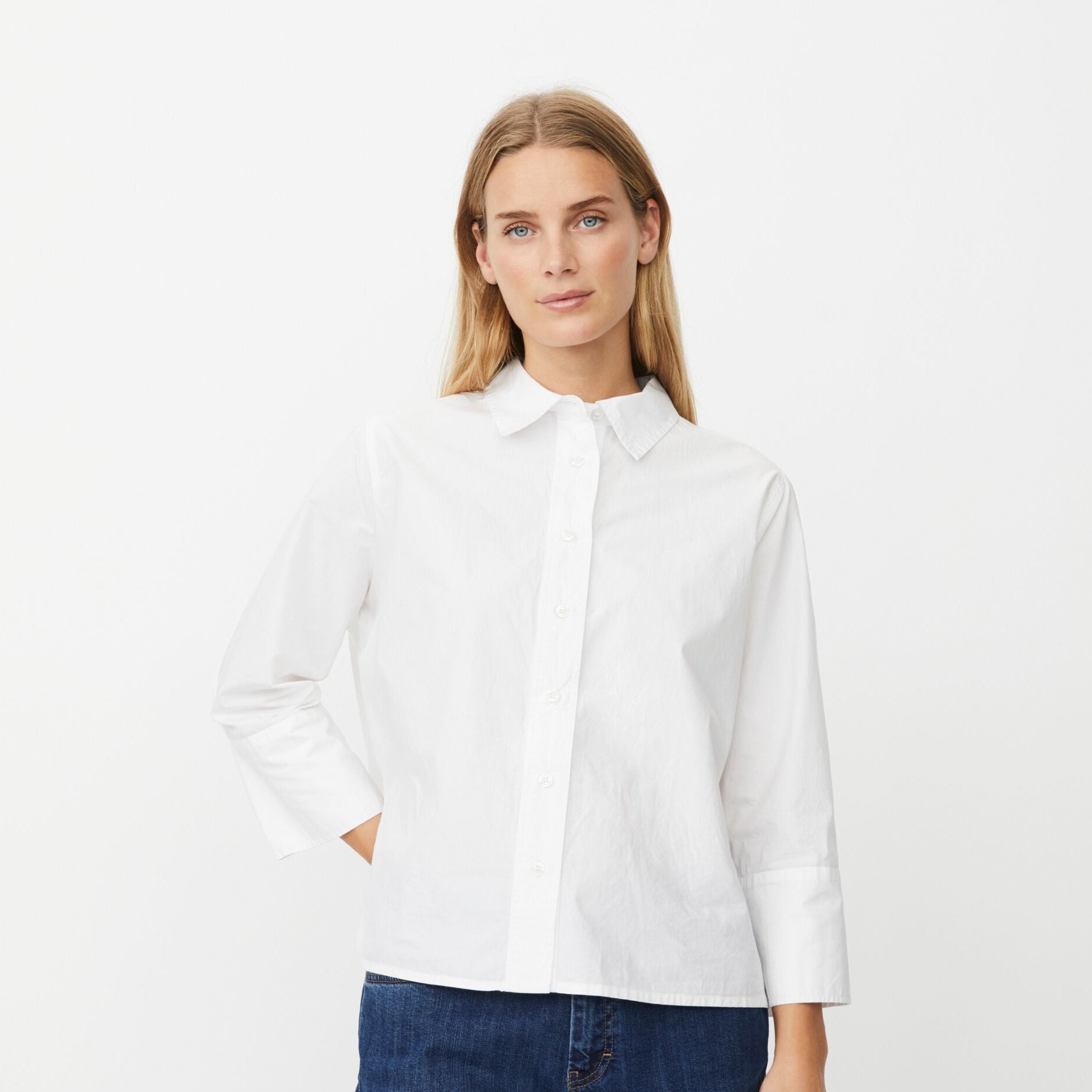 Woman wearing a white shirt and blue jeans on a white background