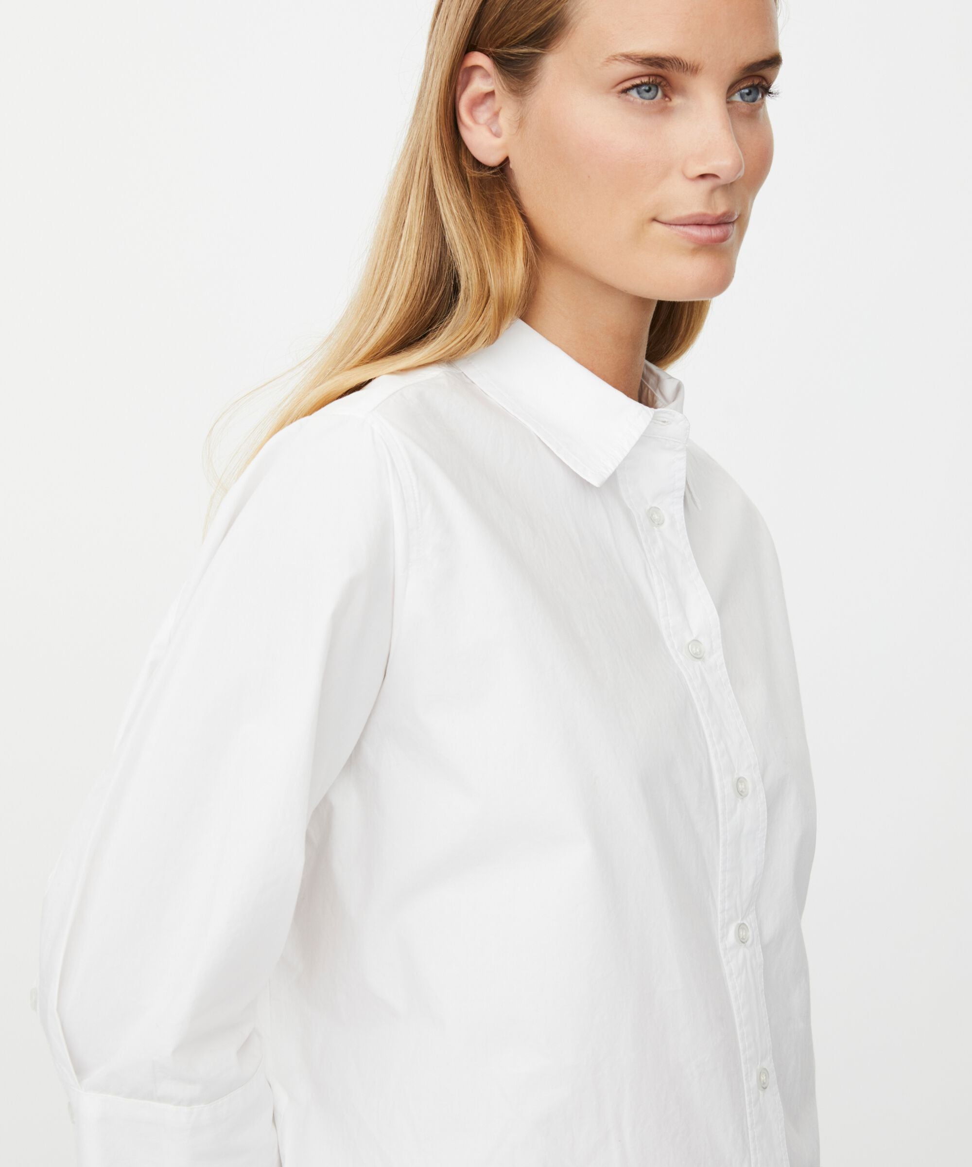 Woman wearing a white shirt against a plain background