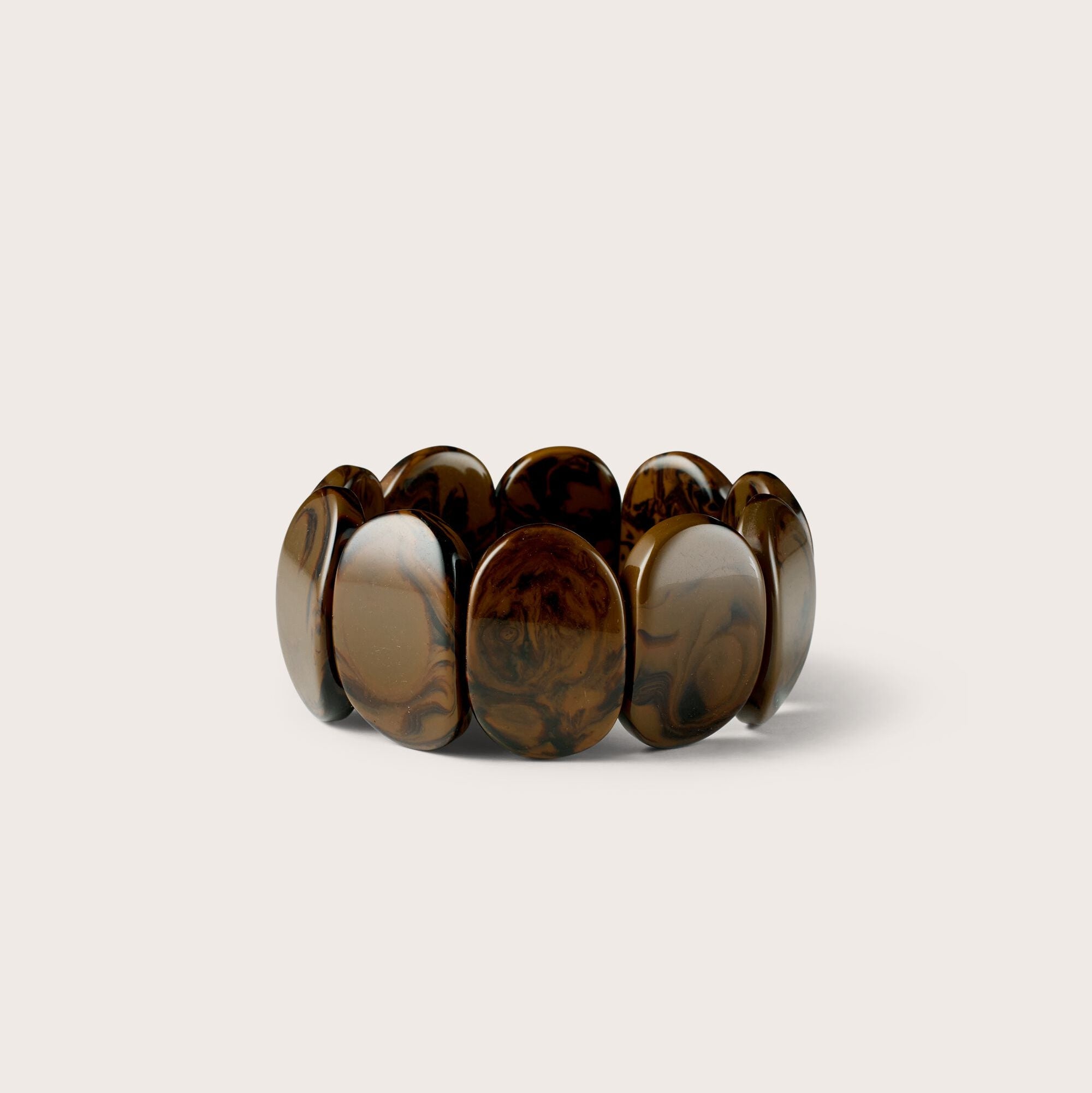 Brown tortoiseshell stretch bracelet on a light beige background